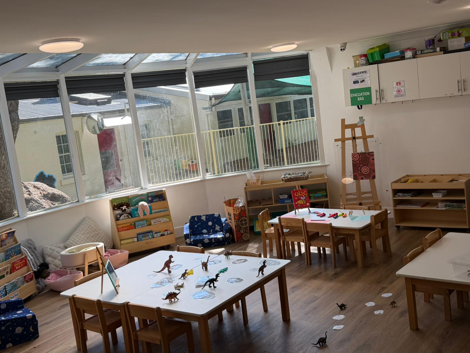 Nursery learning space at Little Woods Early Learning in Glebe with book shelves, a cosy reading corner and low play tables