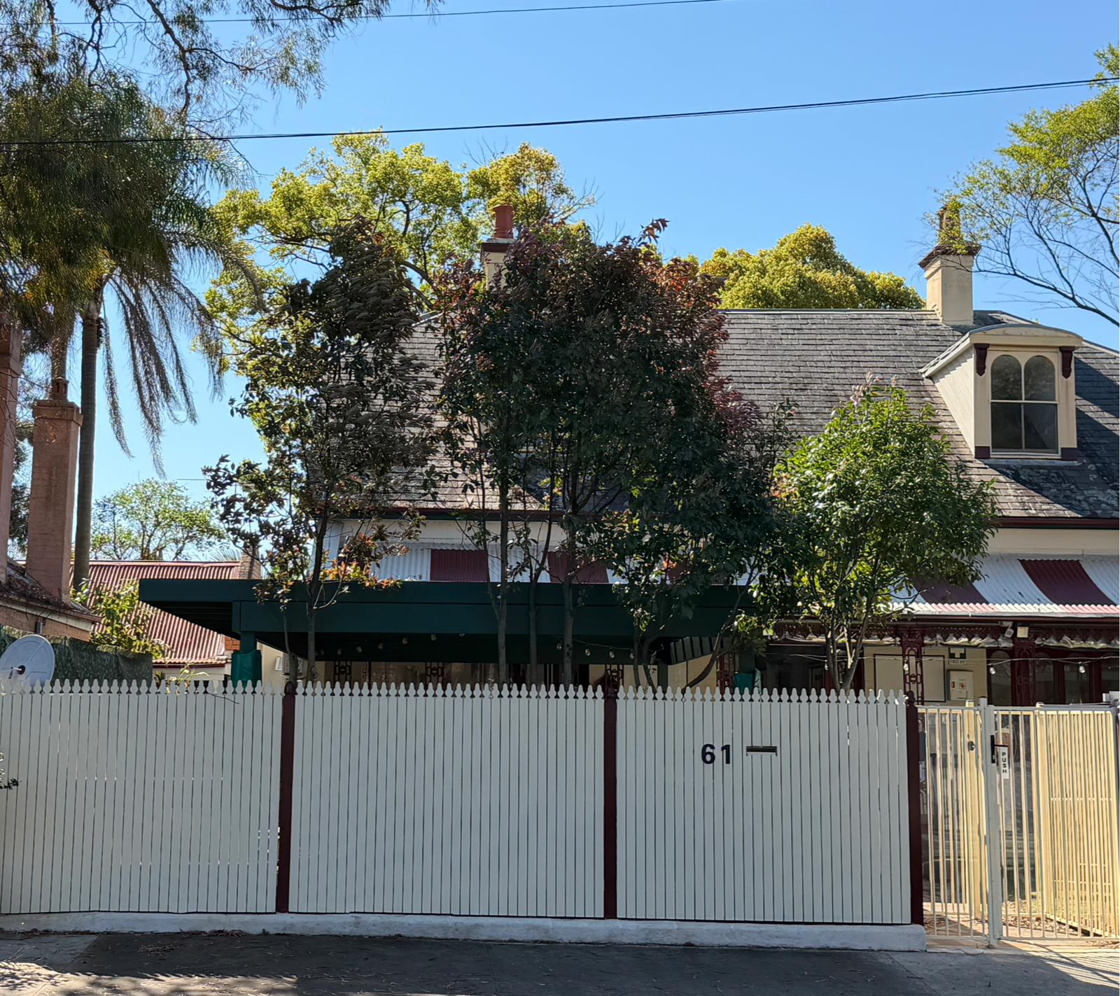 Street frontage of Little Woods Early Learning at 61 Arundel Street, Glebe, with a white picket fence and green verandah