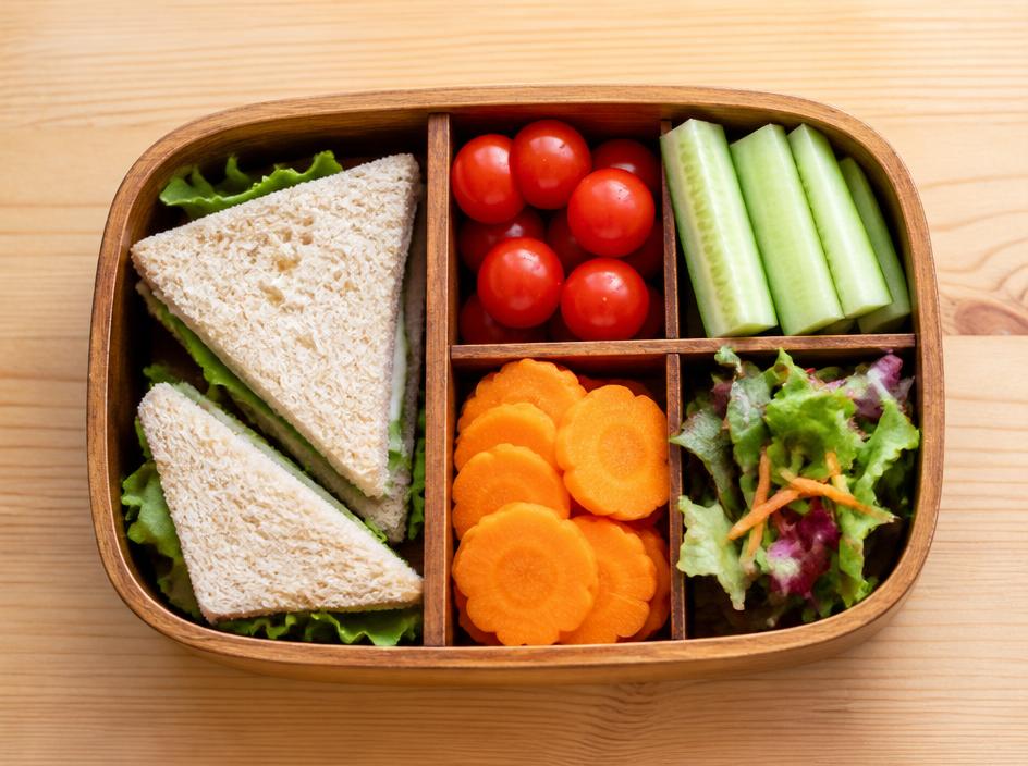 Lunch box with sandwiches, cherry tomatoes, cucumber and carrot
